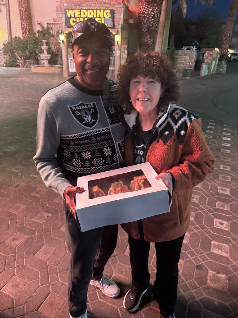 Newlyweds with a box of mini bundts outside a Las Vegas wedding chapel