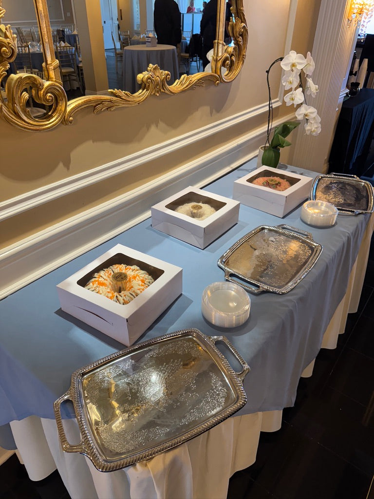 Boozy Bundts dessert table at a wedding reception